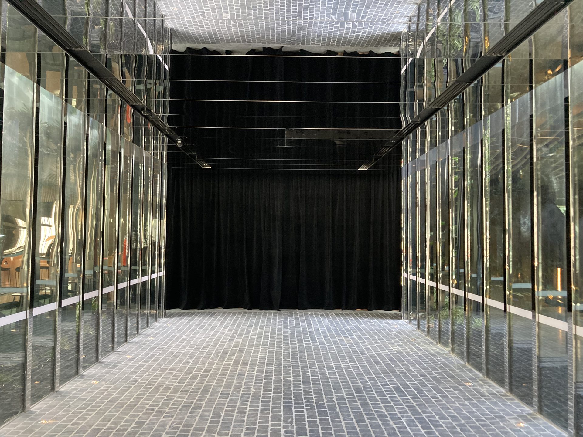 Mirrored event space ending in a full-height black drape