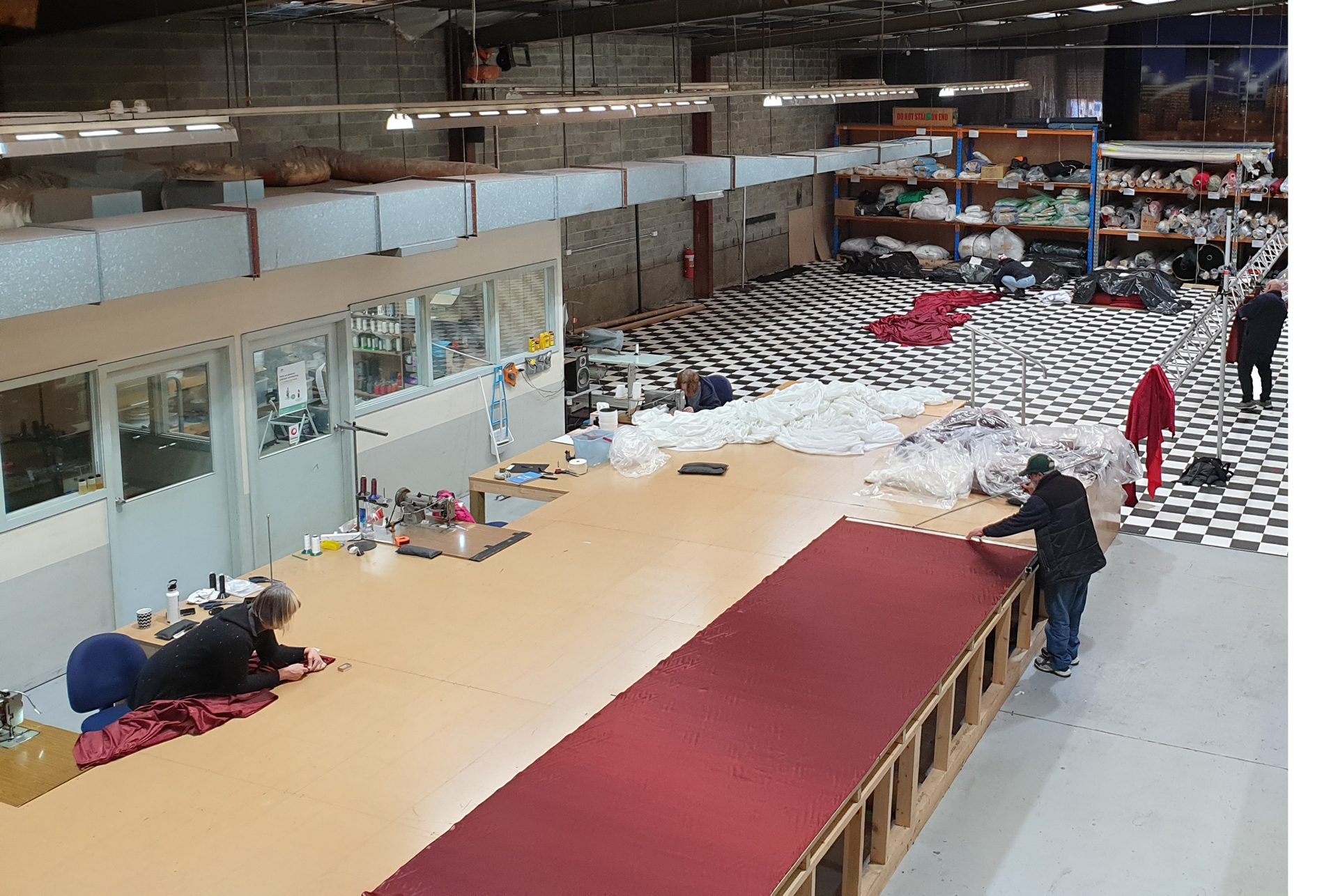 The drape workshop from above, with a red cloth on the cutting table
