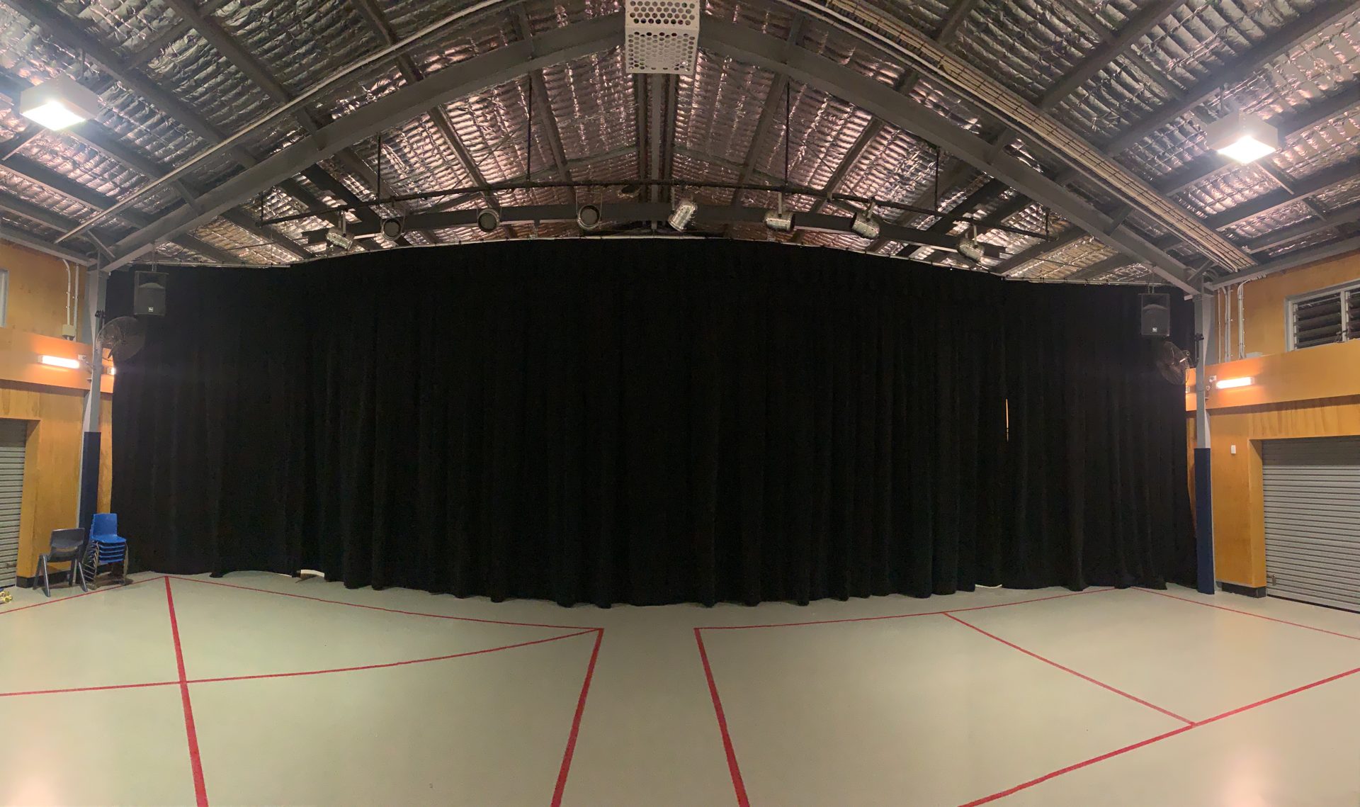 School hall stage fitted with black drapes