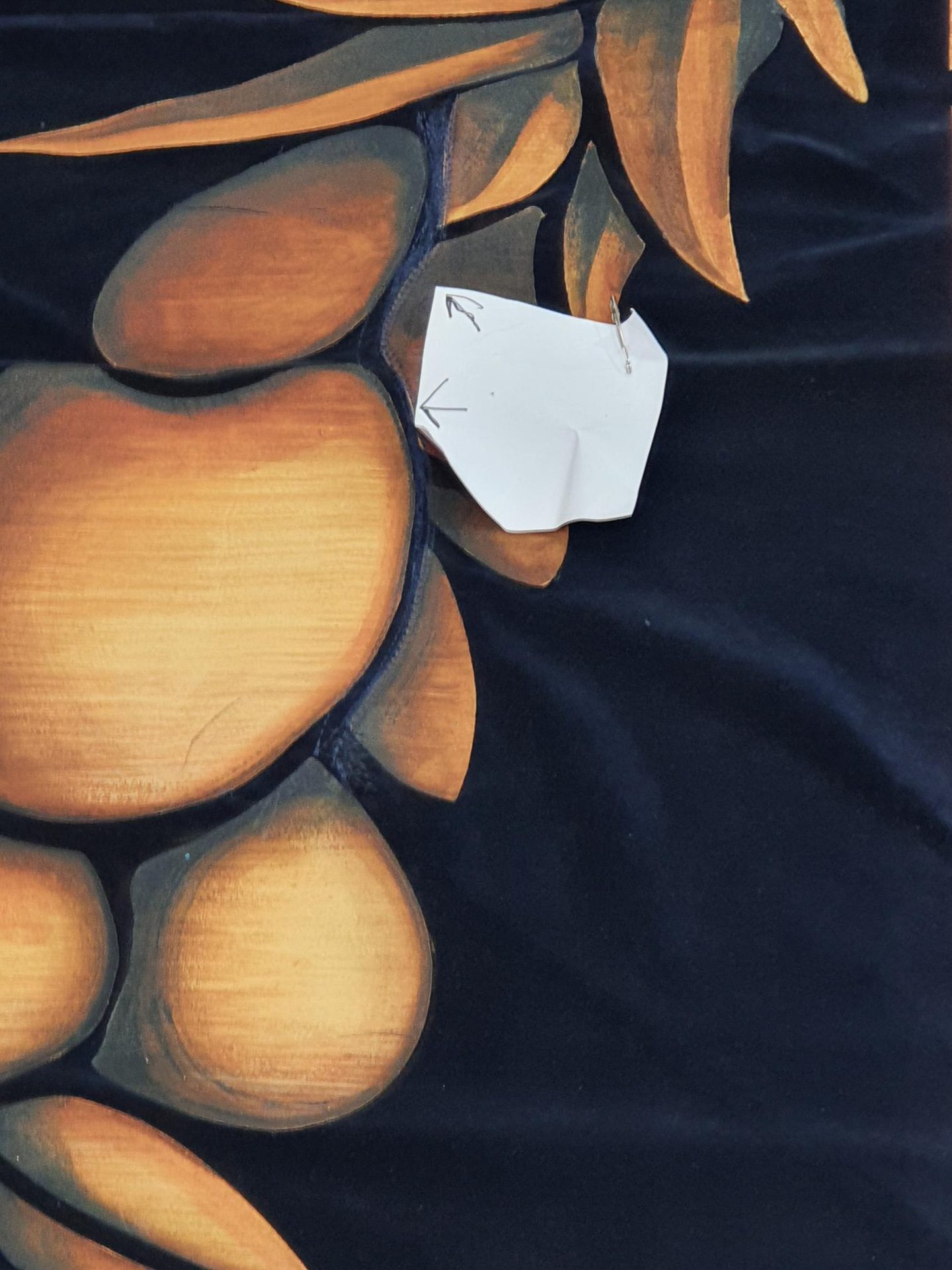 Close-up of printed gold fruit artwork on navy cloth
