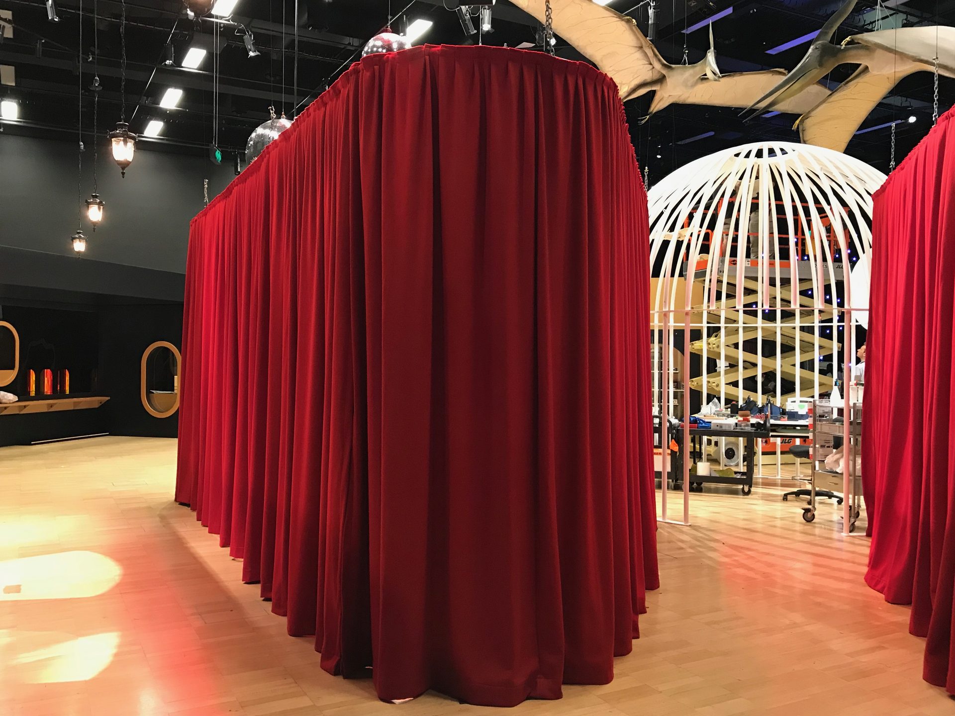 Red velvet hire drapes built into freestanding curtained rooms on a museum exhibition floor