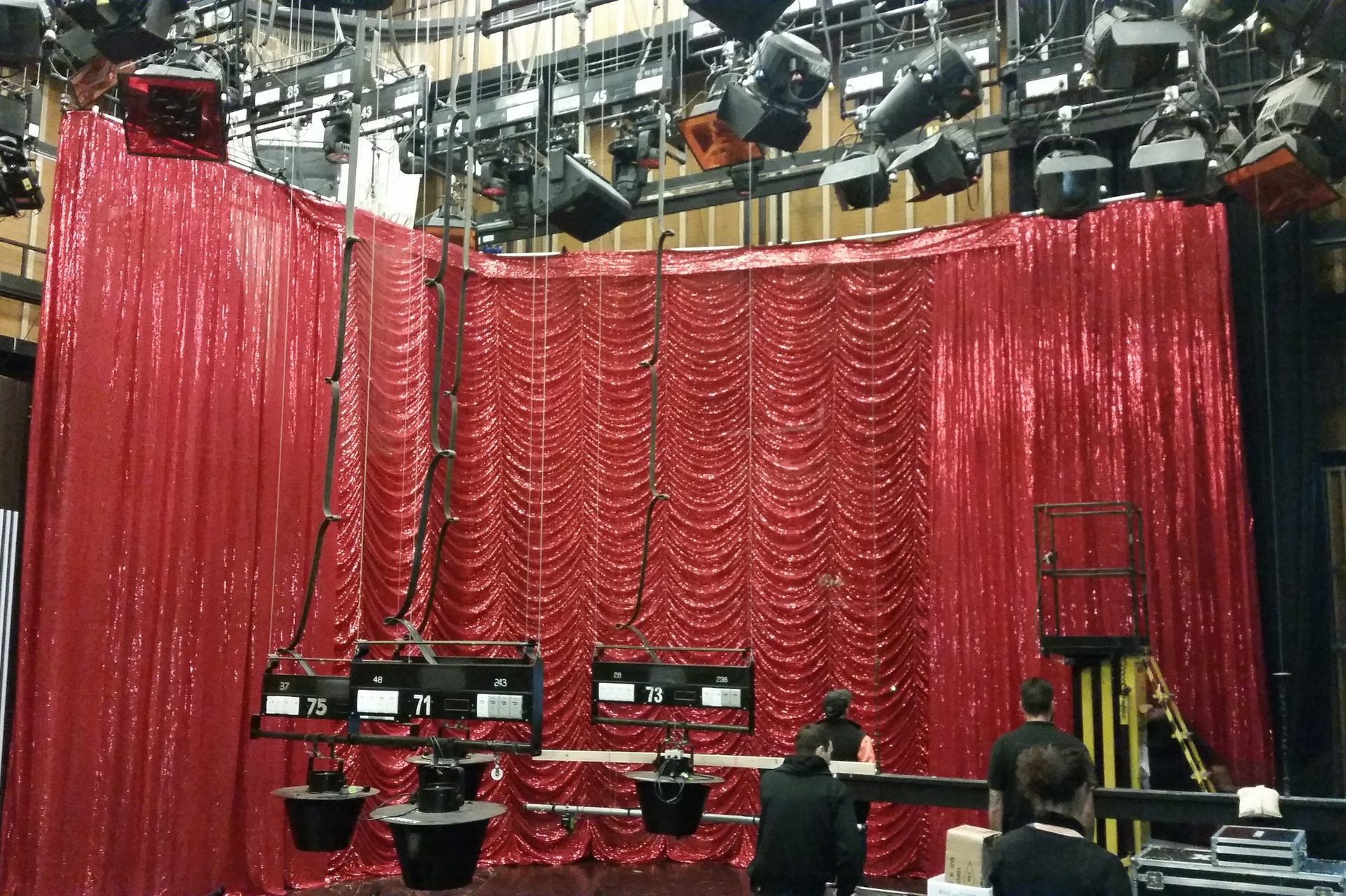 Red festoon hire drapes rigged under the studio lighting grid for The Weekly on ABC