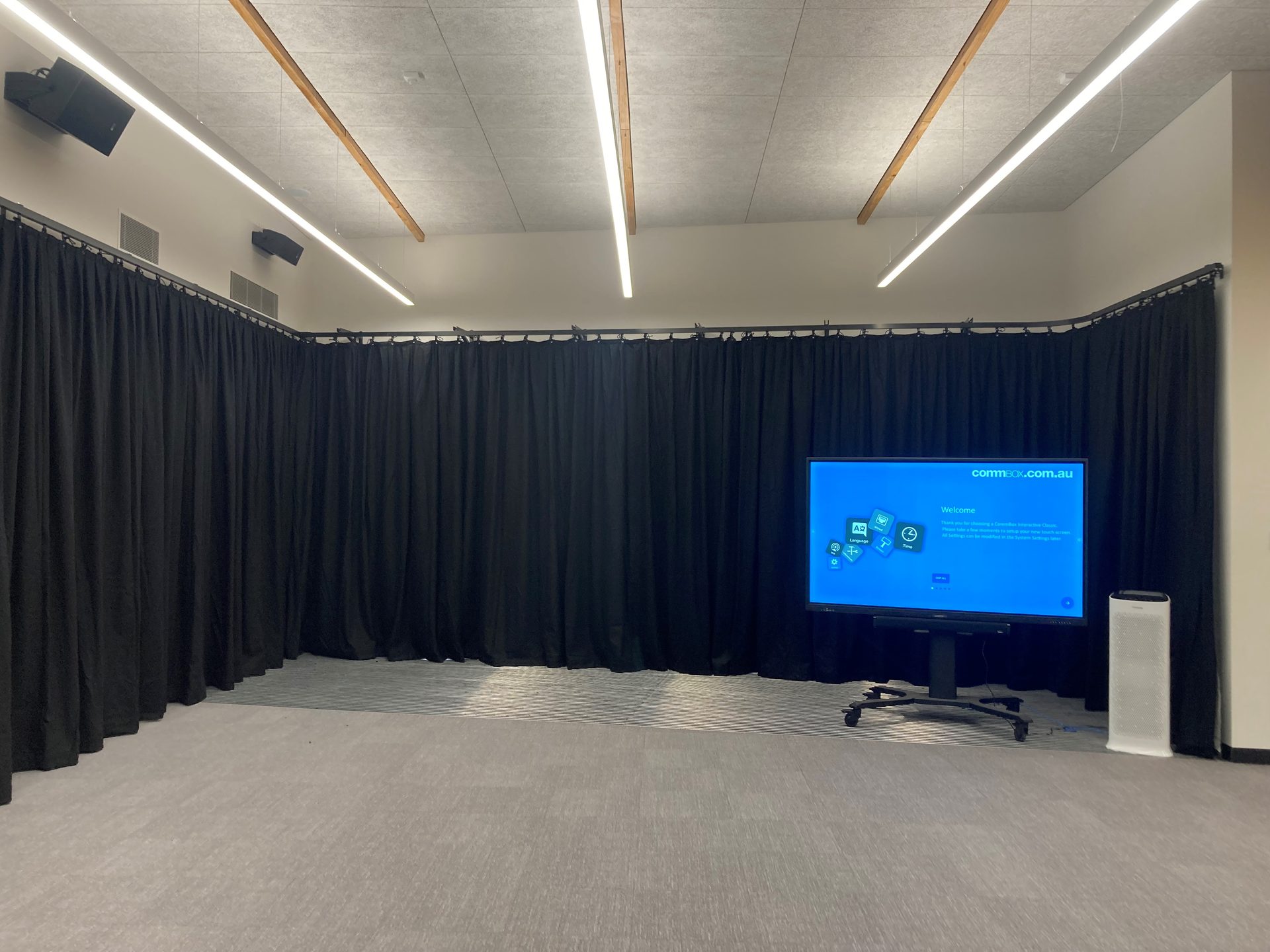 Black drapes on wraparound track in a school drama room