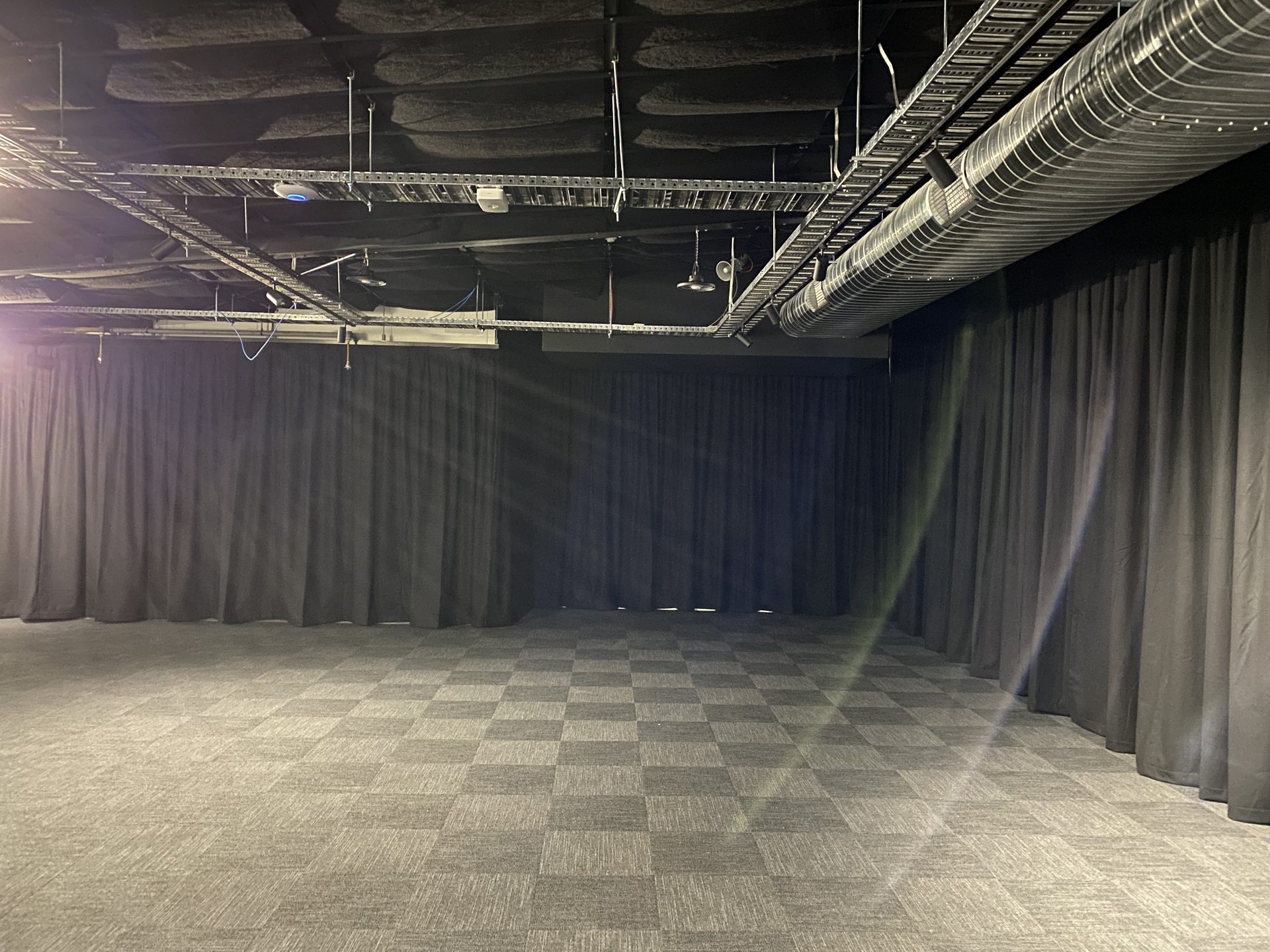 Studio theatre wrapped in black masking drapes hung from perimeter track