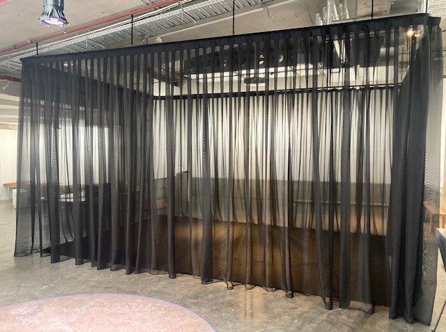 Black sheer voiles on track forming a room inside a gallery