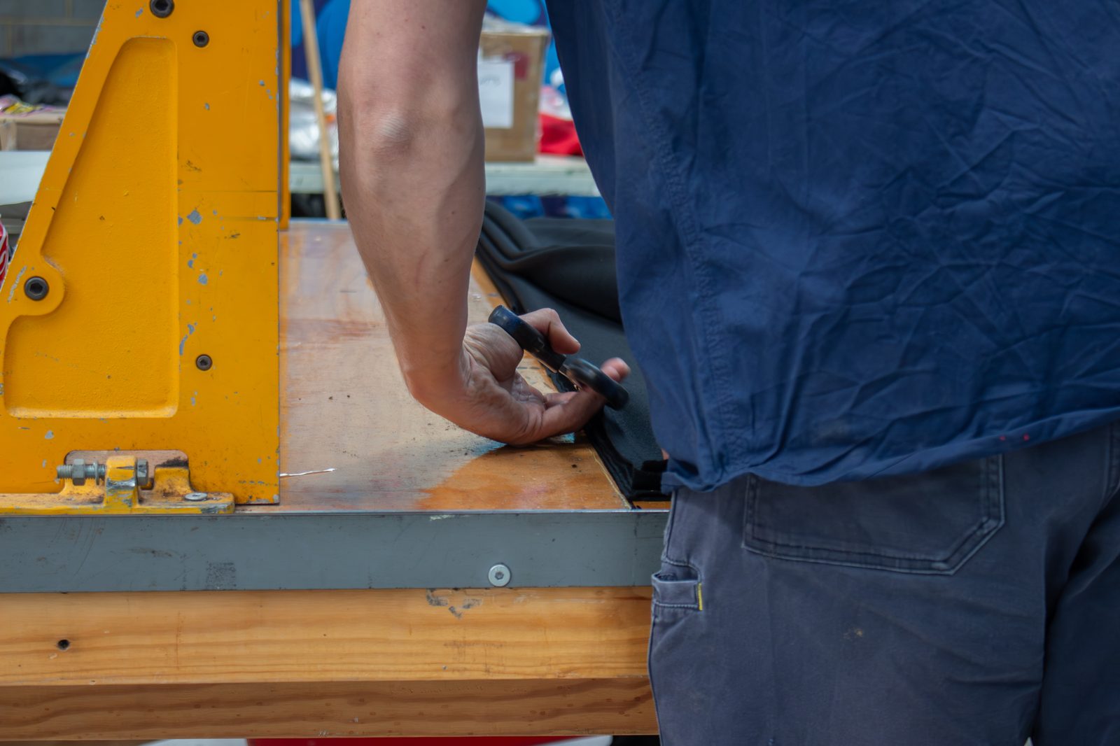 Hands at an eyelet press on the edge of a drape