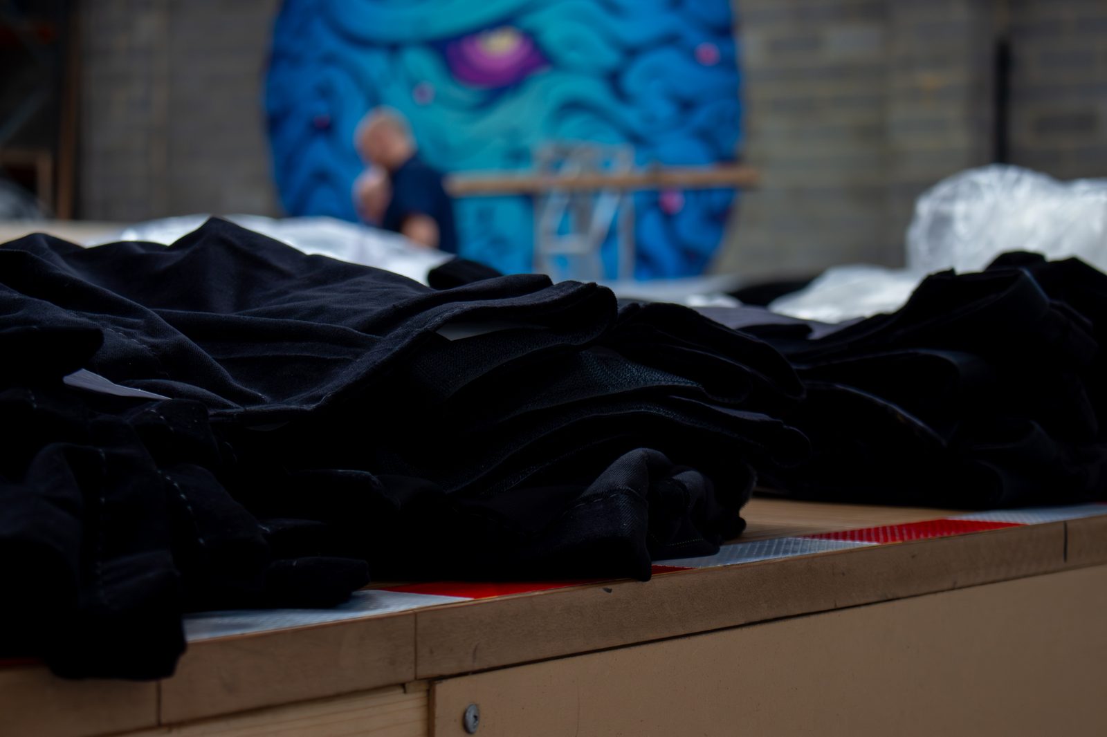 Folded black drapes stacked on a workshop table