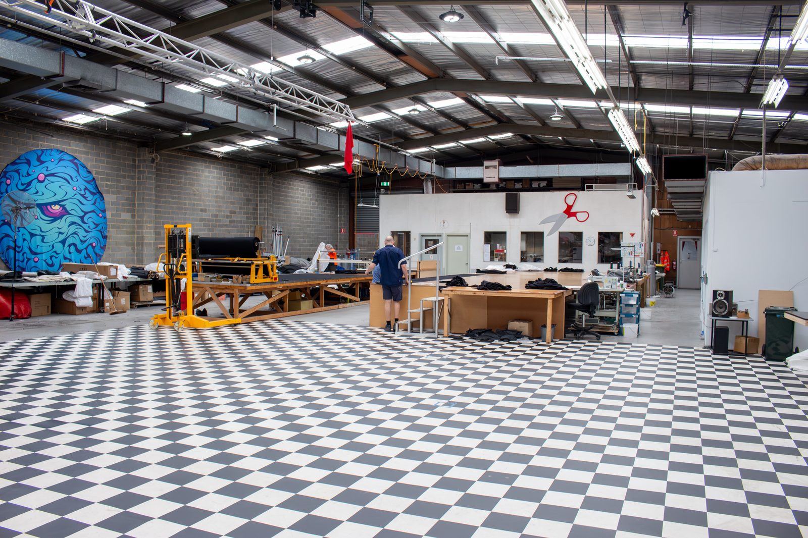 Inside the Reveal Productions workshop in Melbourne, with cutting tables and the checkerboard sewing floor