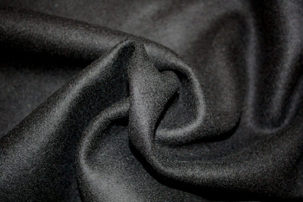 Black wool serge drape hanging in deep matte folds